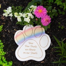 Load image into Gallery viewer, Rainbow paw print memorial garden stone with inspirational text surrounded by white and pink flowers