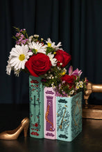 Load image into Gallery viewer, Triple book vase designed like stacked Grimm's fairy tale books filled with red roses and white daisies