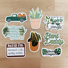 Load image into Gallery viewer, Collection of plant-themed vinyl stickers with humorous sayings on wooden surface