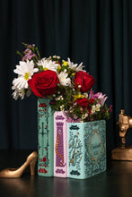 Load image into Gallery viewer, Triple book vase designed as Grimm's fairy tale books holding mixed flower bouquet with roses and daisies