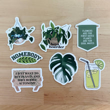 Load image into Gallery viewer, Collection of seven plant-themed vinyl stickers with humorous quotes and botanical designs on wood surface