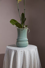 Load image into Gallery viewer, Ribbed teal ceramic vase with orchid plant displayed on white cloth-covered table