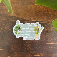 Load image into Gallery viewer, Humorous plant-themed sticker with text about buying more plants on wooden surface