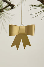 Load image into Gallery viewer, Gold metallic bow-shaped Christmas tree ornament hanging from pine branch