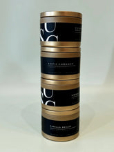 Load image into Gallery viewer, Stack of four luxury scented candles in gold tins with black labels