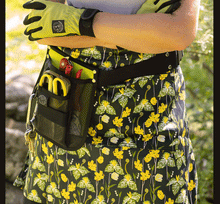 Load image into Gallery viewer, Gardener's half apron with yellow floral pattern and tool pockets worn by person in yellow gloves
