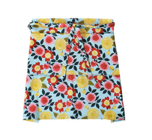 Load image into Gallery viewer, Floral patterned gardener's half apron with tie waist on light blue background