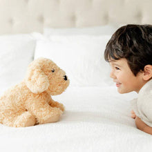 Load image into Gallery viewer, Golden plush dog toy sitting on white bedding with smiling child nearby