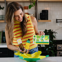 Load image into Gallery viewer, Woman unpacking plant food starter kit with bottles and instruction cards in kitchen