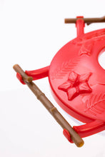 Load image into Gallery viewer, Red plastic hummingbird feeder with decorative star design and wooden perch rods