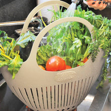 Load image into Gallery viewer, Beige plastic colander with handles holding fresh vegetables being rinsed with water