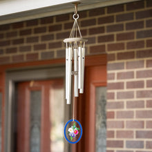 Load image into Gallery viewer, Wind chime with silver tubes and floral disc hanging from brick porch ceiling
