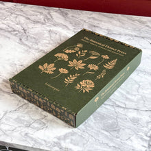 Load image into Gallery viewer, Green linen botanical flower press with gold foil plant illustrations on marble surface