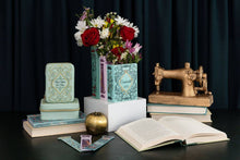 Load image into Gallery viewer, Decorative book-shaped vase holding colorful flowers with fairy tale themed styling and vintage accents