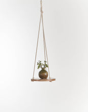 Load image into Gallery viewer, Round wooden hanging shelf with cotton rope suspension displaying small glass vase with green plant