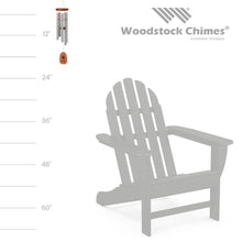 Load image into Gallery viewer, Woodstock wind chime with silver tubes and wooden paw print striker beside Adirondack chair for size reference
