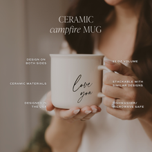 Load image into Gallery viewer, White ceramic campfire mug with 'love you' text being held in hands