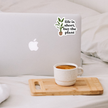 Load image into Gallery viewer, Life is short buy the plant sticker on laptop with coffee cup on wooden tray