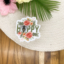 Load image into Gallery viewer, Bee Happy floral vinyl sticker with watercolor flowers and bee illustration on woven placemat