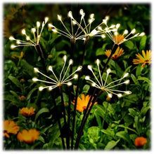 Load image into Gallery viewer, LED solar dandelion burst garden stakes with white lights illuminated among orange flowers and green foliage