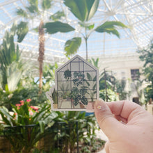 Load image into Gallery viewer, Hand holding greenhouse-shaped sticker with illustrated plants against tropical nursery background