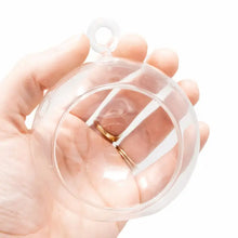 Load image into Gallery viewer, Hands holding clear glass terrarium globe with hanging loop and wedding rings inside