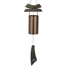 Load image into Gallery viewer, Bronze wind chime with wooden sail and cylindrical metal tube hanging outdoors