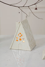 Load image into Gallery viewer, White ceramic quilted cabin tealight holder with warm glowing cutout window details