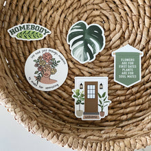 Load image into Gallery viewer, Collection of plant-themed vinyl stickers featuring monstera leaf, homebody text, and botanical quotes on wicker basket