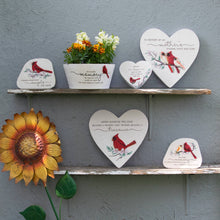 Load image into Gallery viewer, Memorial stones featuring cardinal designs and inspirational quotes displayed on wooden shelves with decorative flowers