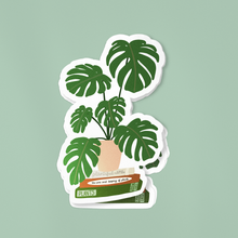 Load image into Gallery viewer, Monstera plant sticker design featuring green leaves growing from stacked plant care books