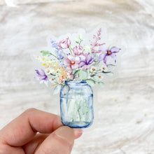 Load image into Gallery viewer, Hand holding watercolor sticker of blue mason jar with purple and pink spring flowers