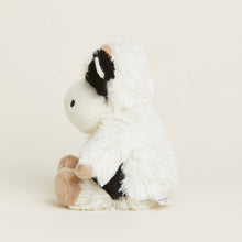 Load image into Gallery viewer, White fluffy stuffed cow toy with black ears and hooves on beige background
