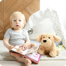 Load image into Gallery viewer, Blonde toddler sitting with golden plush dog toy and books on nursery rug