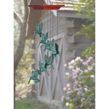 Load image into Gallery viewer, Verdigris hummingbird spiral wind chime with copper top hanging in garden setting