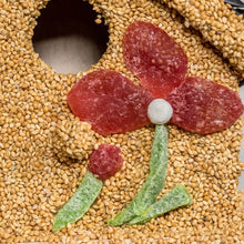 Load image into Gallery viewer, Bird seed cake shaped like flower with red petals and green leaves on sesame seeds
