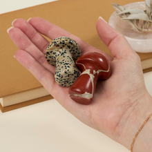 Load image into Gallery viewer, Hand holding decorative stone mushrooms in red jasper and dalmatian jasper varieties