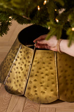 Load image into Gallery viewer, Gold hammered metal scalloped Christmas tree collar being assembled around tree base