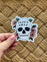 Load image into Gallery viewer, Hand holding white skull sticker with pink flowers and 'Plant Killer' text on rope background