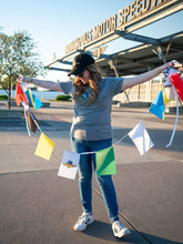 Load image into Gallery viewer, Woman holding colorful racing flags bunting with various international and racing-themed flag designs