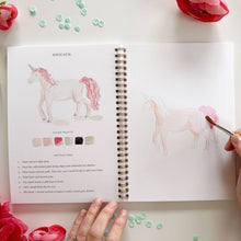 Load image into Gallery viewer, Open watercolor workbook showing unicorn painting tutorial with color palette and step-by-step instructions
