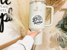Load image into Gallery viewer, White Stanley mug with Find Me In The Garden circular sticker featuring wheelbarrow design