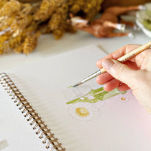 Load image into Gallery viewer, Hand painting watercolor vegetables in spiral-bound sketchbook with brush and dried corn nearby