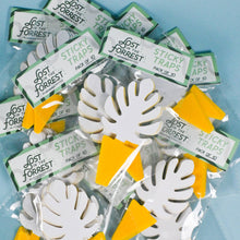 Load image into Gallery viewer, White leaf-shaped sticky traps with yellow tabs scattered on blue surface in clear packages