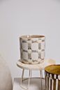 Load image into Gallery viewer, White ceramic Anselm pot with geometric cutout pattern on wooden stool