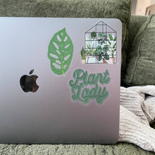 Load image into Gallery viewer, Clear vinyl stickers on MacBook laptop including green monstera leaf and plant lady text with greenhouse illustration