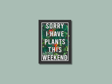 Load image into Gallery viewer, Framed sticker with white text saying Sorry I Have Plants This Weekend on tropical foliage background
