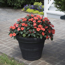 Load image into Gallery viewer, Black ceramic planter with coral-orange impatiens flowers on brick patio