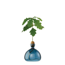 Load image into Gallery viewer, Blue glass acorn-shaped vase with wooden cork top holding green oak leaf branch