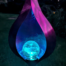 Load image into Gallery viewer, Illuminated teardrop-shaped metal garden stake with glowing blue orb and pink LED accents at night